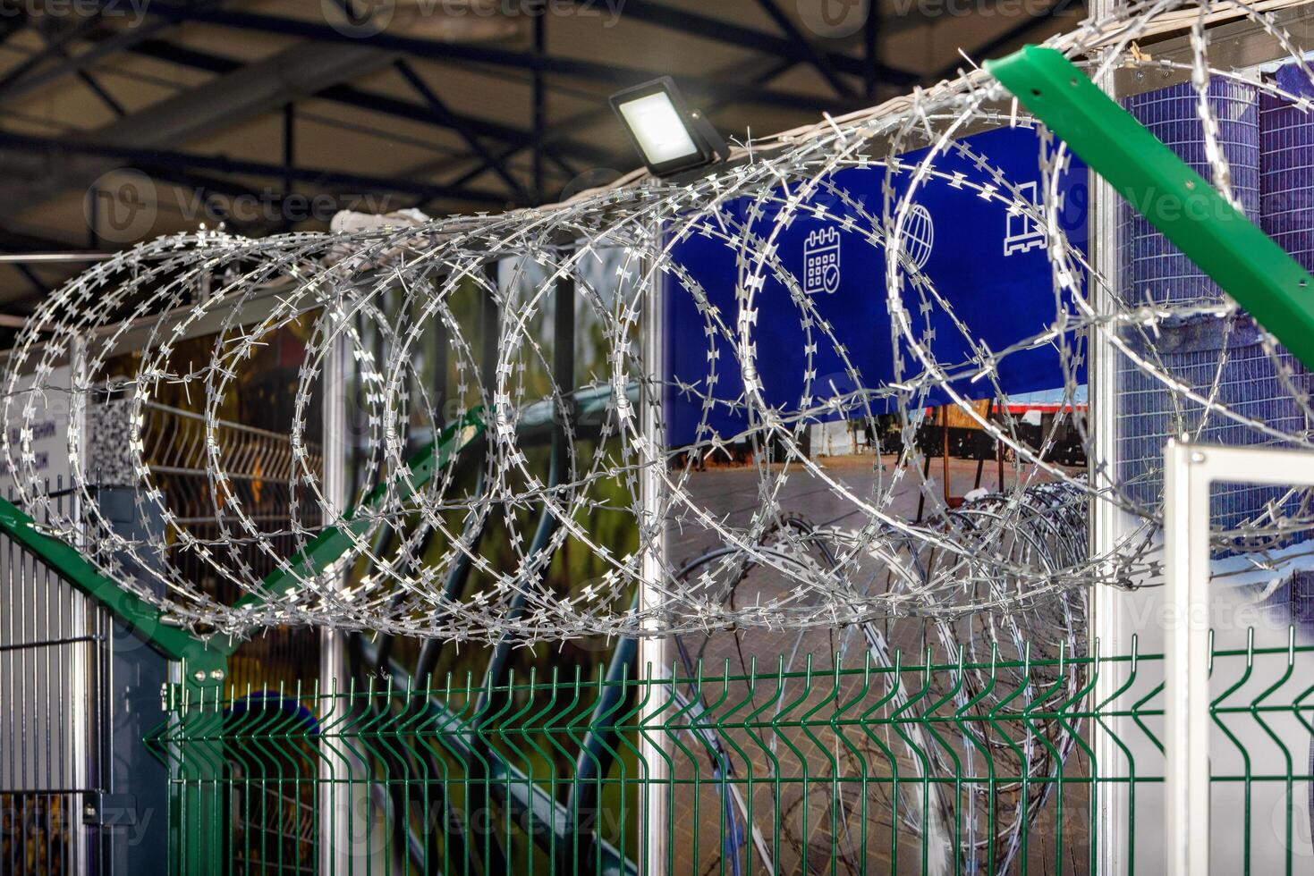 Iron fence with barbed wire and a light element, no entry. Protection of the territory and counteraction to illegal entry. photo