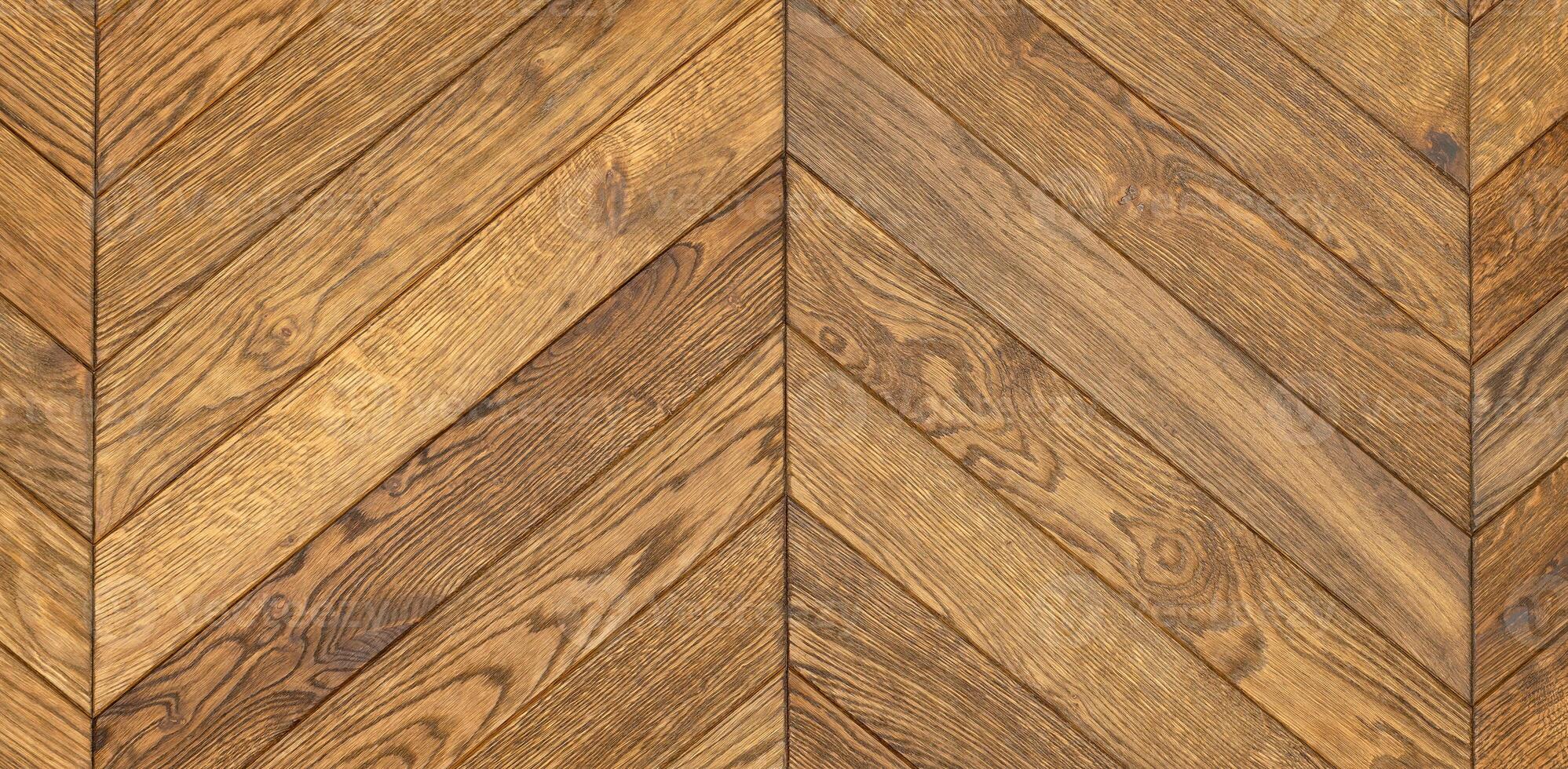 Dark oak wood flooring in a herringbone shape with a clear grain pattern. photo