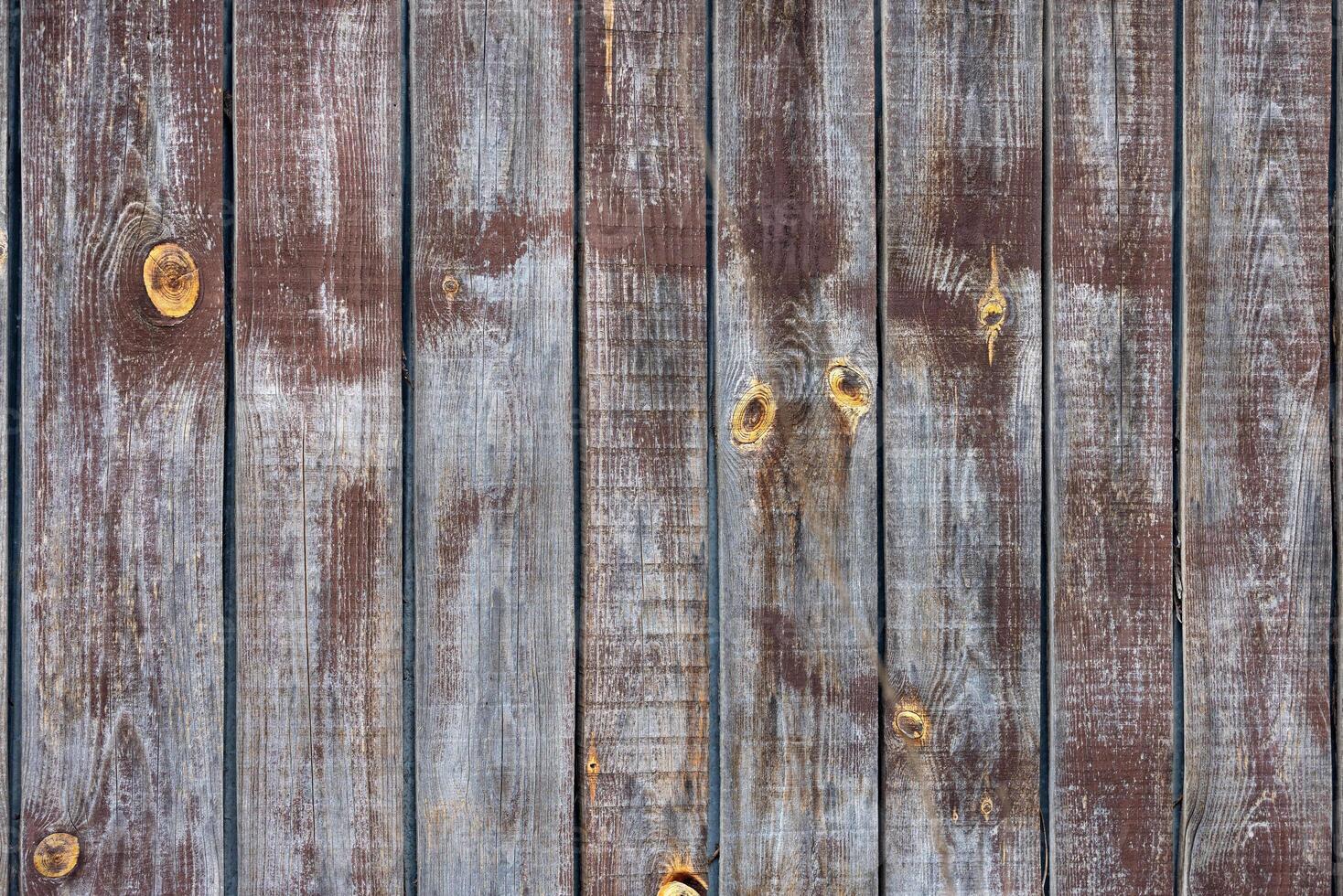 The texture of an old weathered fence with a clear structure of fibers and knots. photo