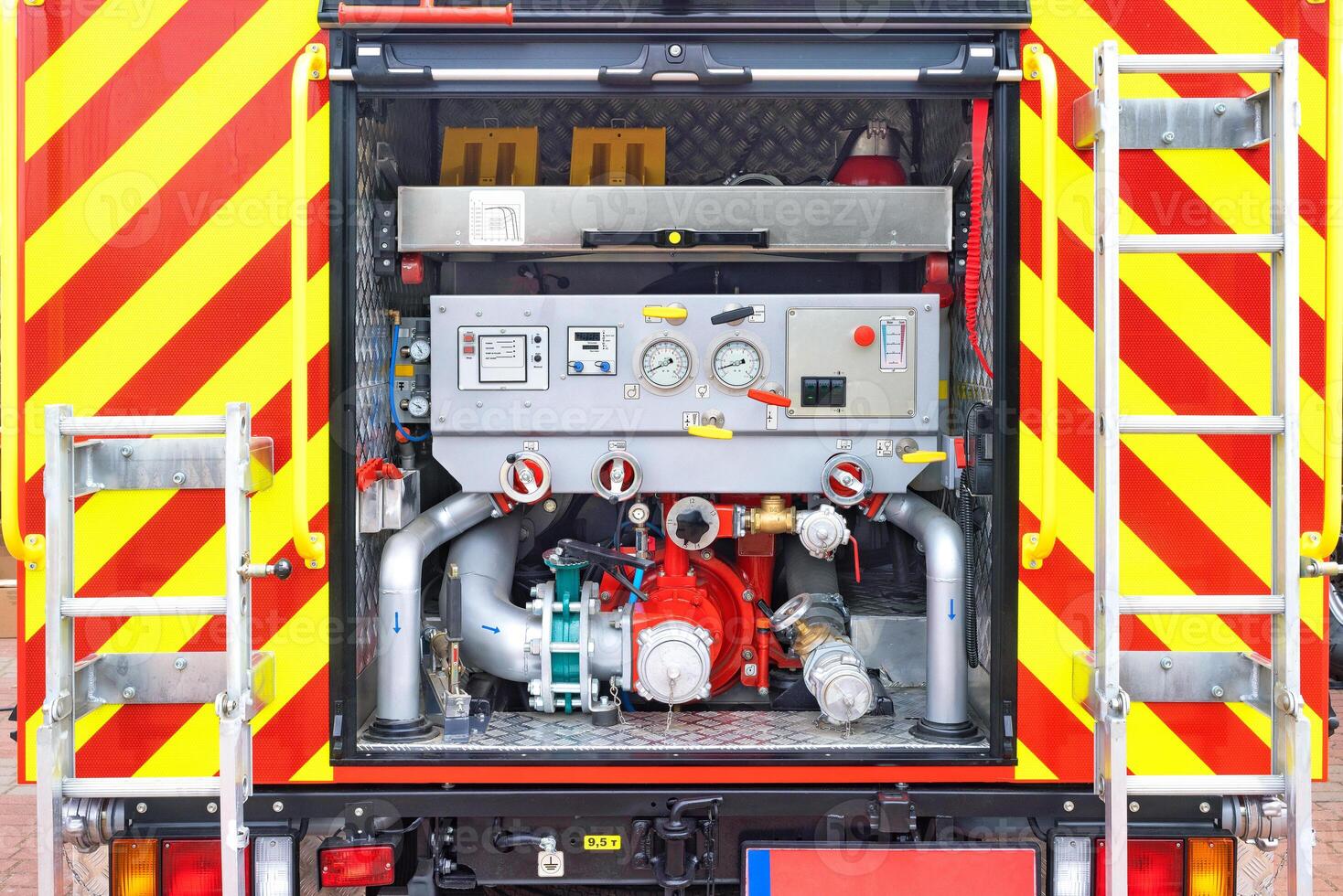 Close-up view of the pumping unit compartment from the rear of a fire truck. photo