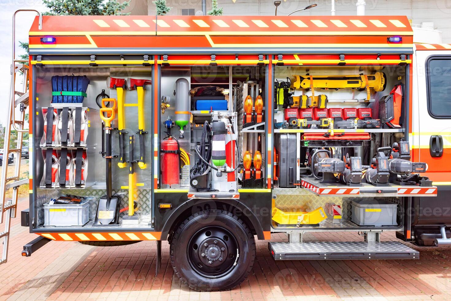 Firefighter equipment organized in compartments on a truck featuring tools, hoses, helmets for emergency response concept photo