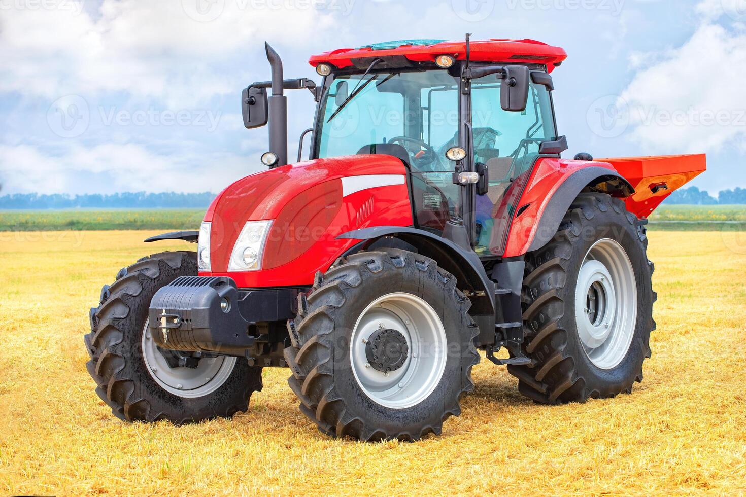 Powerful red tractor in vast wheat field under blue sky, showcasing modern agricultural machinery concept photo