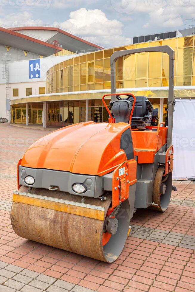 Heavy machinery smoothing pavement at a construction site near an architectural landmark photo
