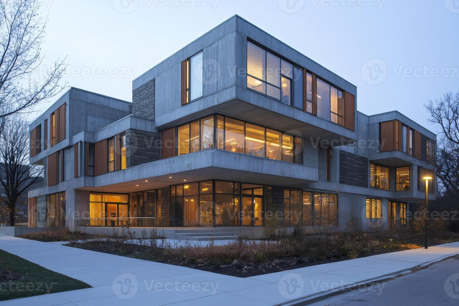 Modern concrete building with large windows glowing at dusk photo