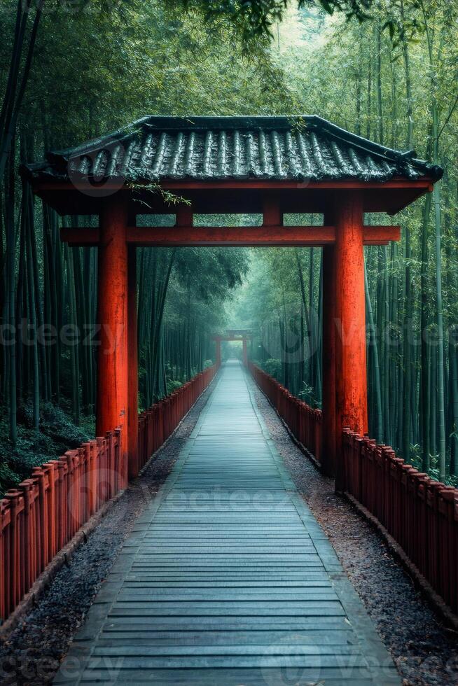 Red torii gate leading to pathway surrounded by bamboo forest photo