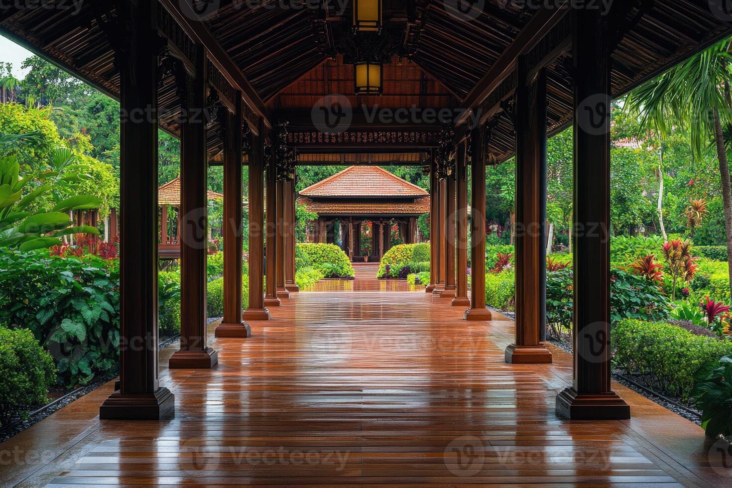 Wooden covered walkway leading to traditional asian pavilion in tropical garden photo