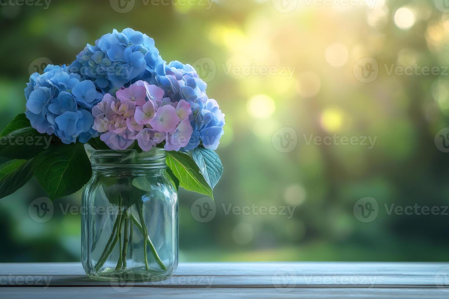 Bouquet of hydrangeas in a glass jar on a wooden table with blurred garden background photo