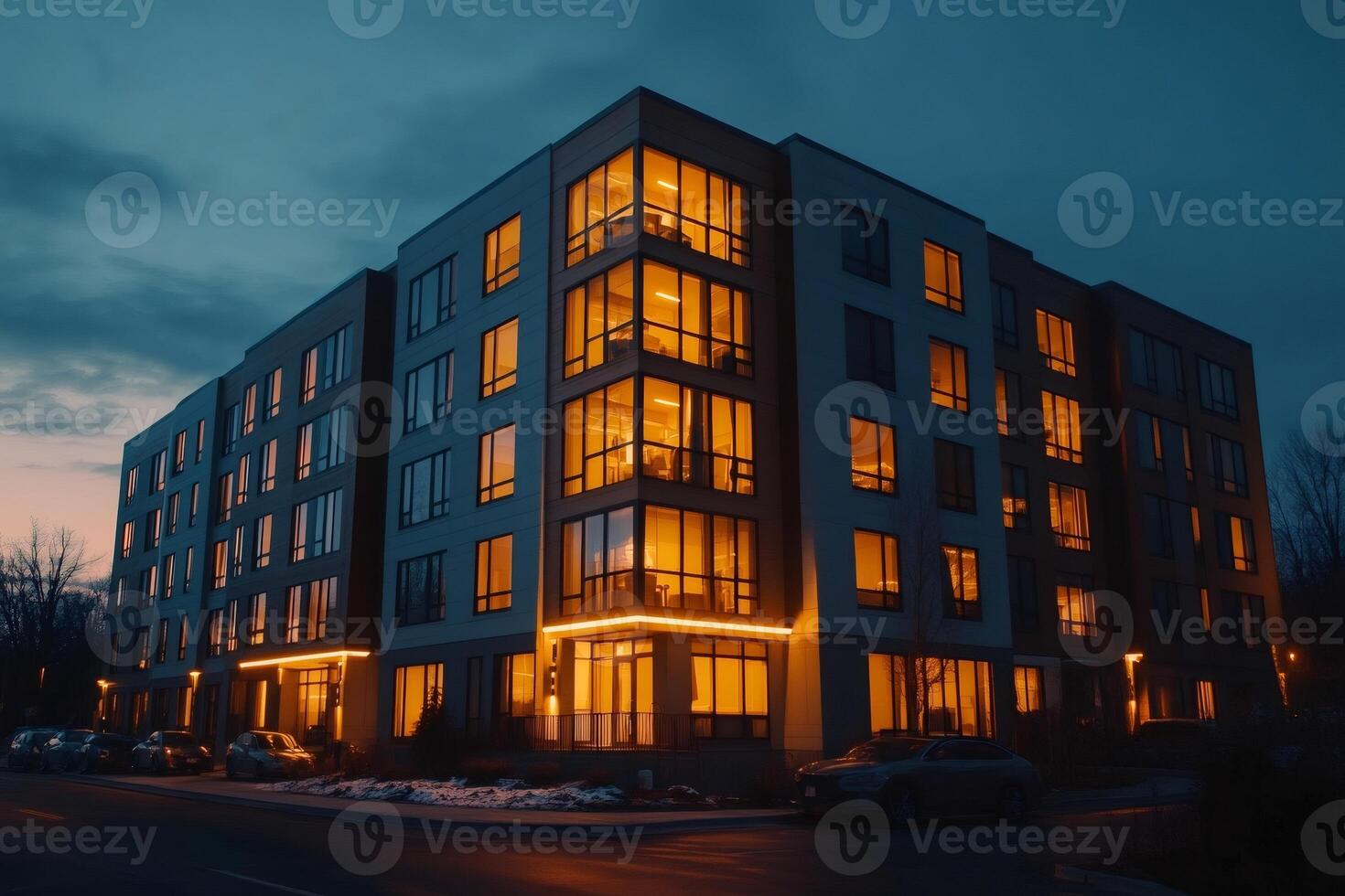 Modern apartment building with glowing windows at dusk in winter photo