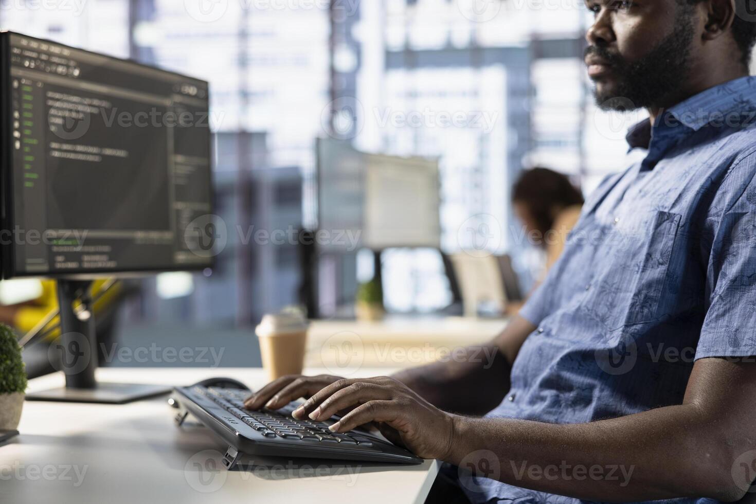 Computer scientist in office fixing applications issues, dealing with databases and server configuration. African american IT expert optimizing company software for improved performance photo