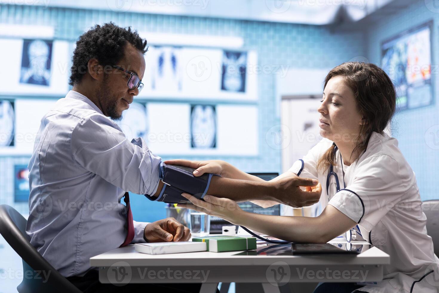 Physician measuring pulse and controlling blood pressure for a patient, using blood pressure monitor during check up visit. Doing a consultation on health insurance, medical services. photo