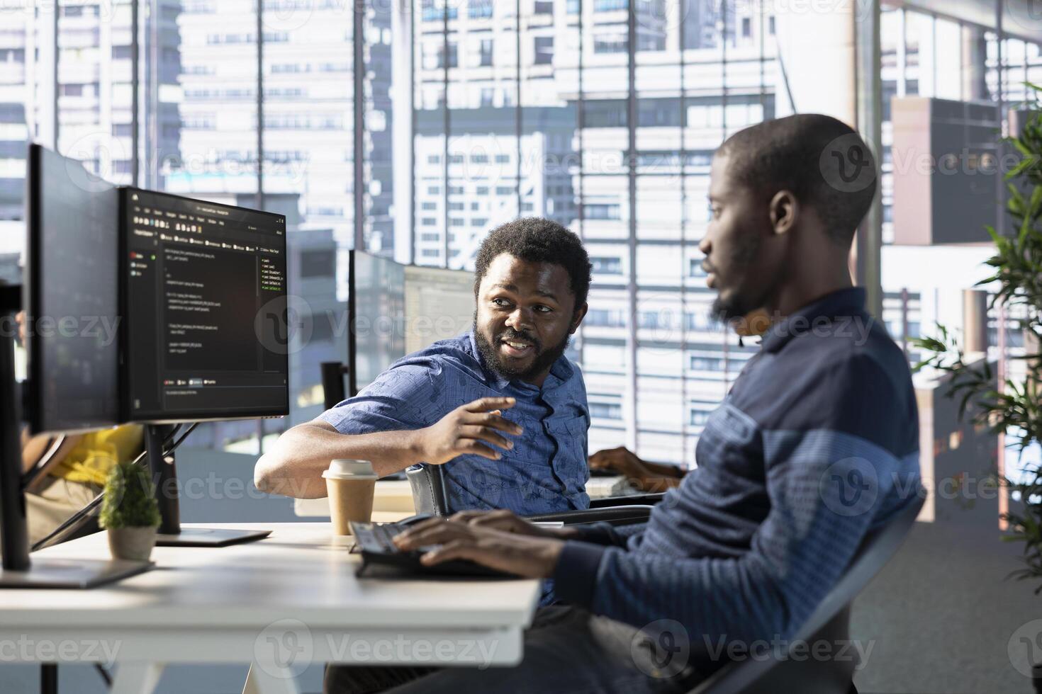 Manager in wheelchair checks on employee testing machine learning company software to minimize occurrence of bugs, identifying bottlenecks. Team leader with disability supervising worker writing code photo