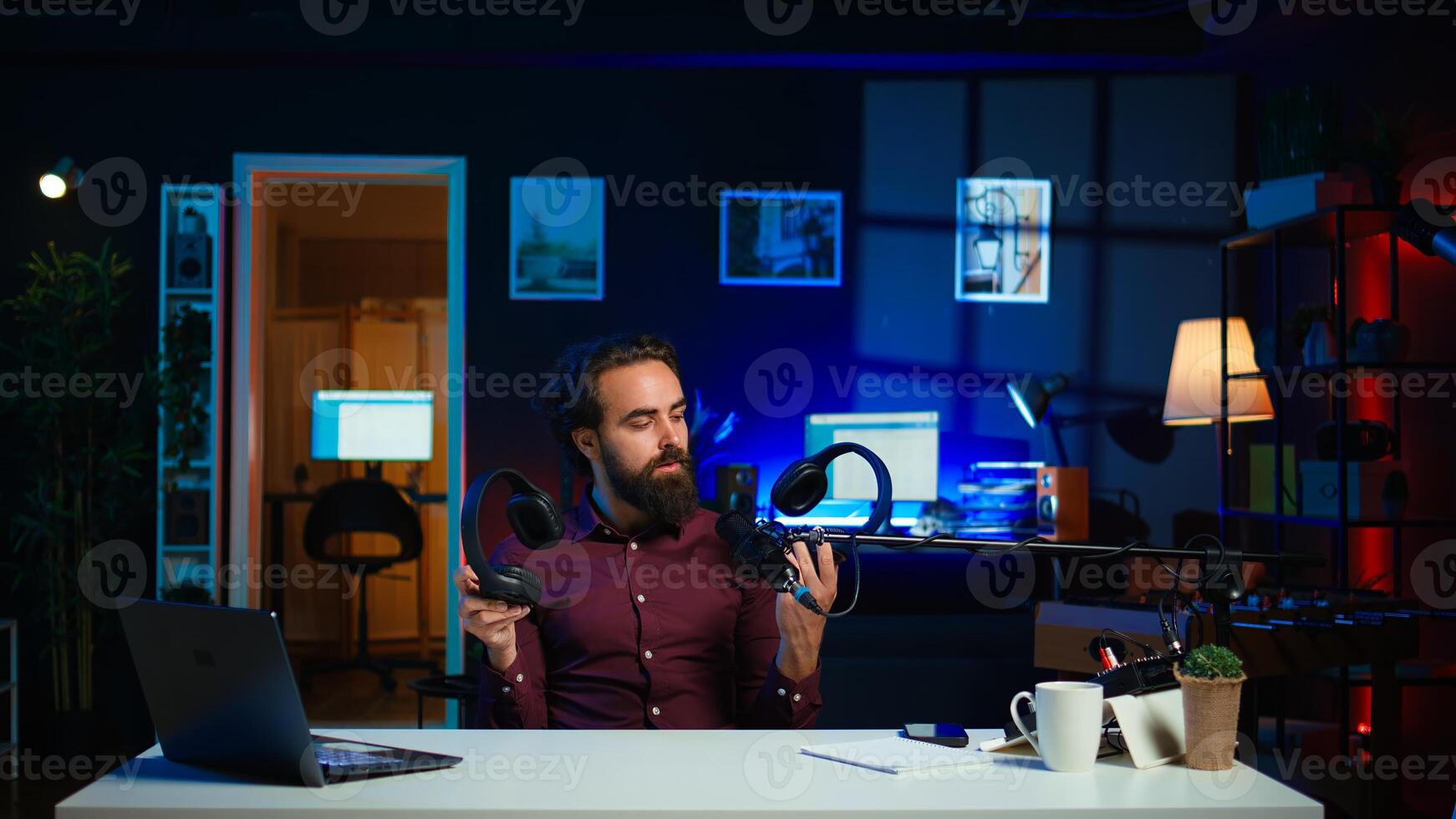 Tech expert testing headphones, review them for online streaming platforms. Professional audiophile hosts internet show, using sound mixer to check audio device sound sensitivity, camera B photo