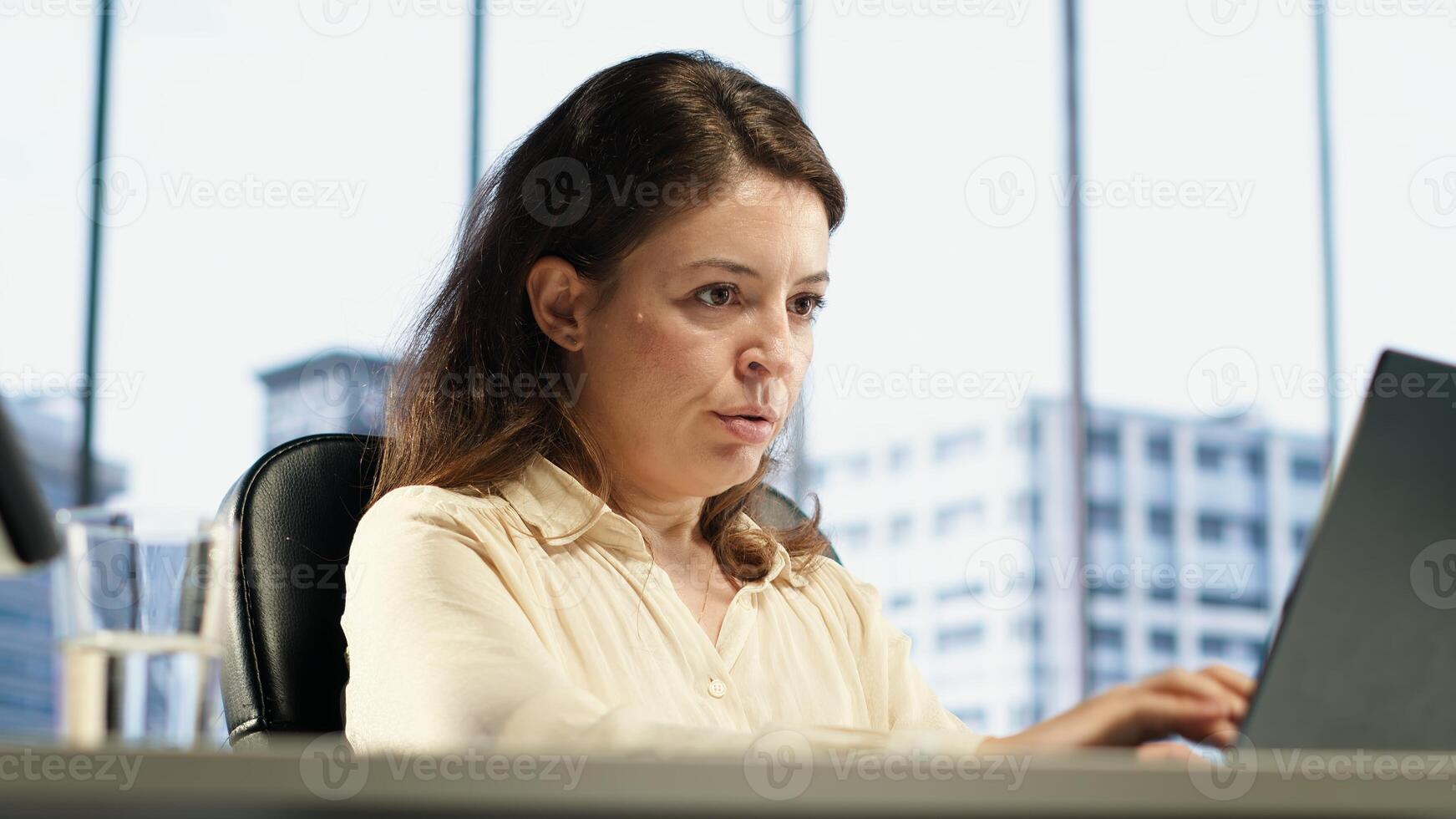 Anxious frustrated entrepreneur having a headache at work, feeling overburdened and uncomfortable with tension and project deadline. Exhausted unwell businesswoman on the job. Camera A. photo