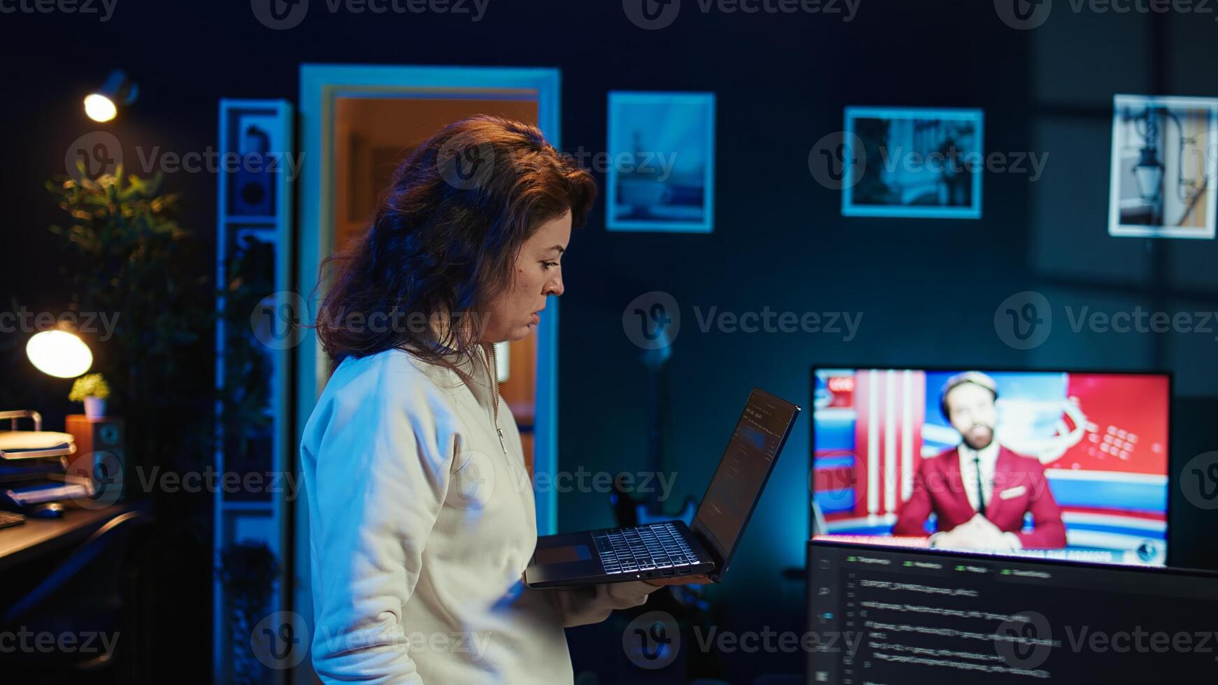 Developer doing software debugging using laptop, checking glitches in lines of code, upset about errors. Woman walking around home fixing coding issues using notebook device, camera B photo