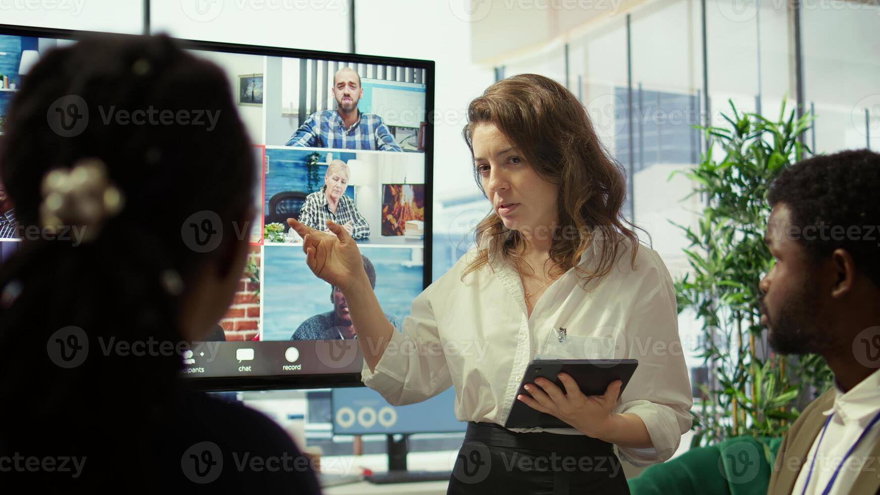 Employees attending an online remote videocall meeting with general manager, presenting project updates for efficiency. Work team ensuring strategic goals achievement in a boardroom. Camera B. photo