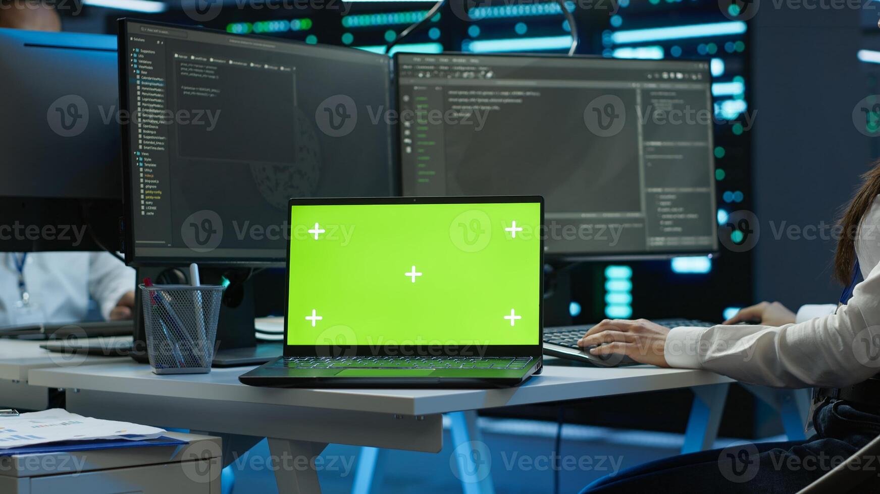 Data center engineer responsible for installation of networking equipment solving tasks on isolated screen laptop. Woman doing maintenance on server room infrastructure using mockup notebook, camera A photo