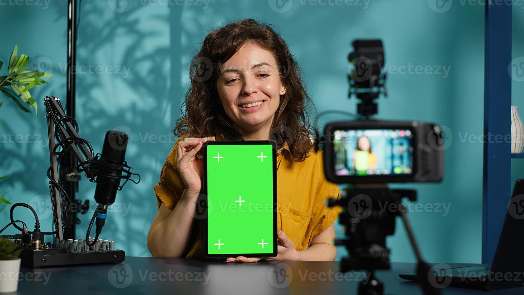 Woman filming tech tutorial on how to repair damaged mockup tablet using professional camera. Engineer teaching fans to install operating system on green screen device, recording with gear, camera A photo