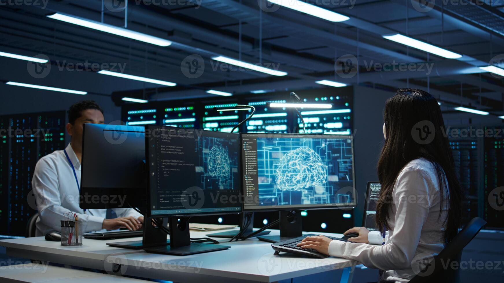 Technicians coworkers using AI tech on computer to do checkup in server room. Teamworking colleagues in data center using artificial intelligence technology to process datasets for training, camera B photo