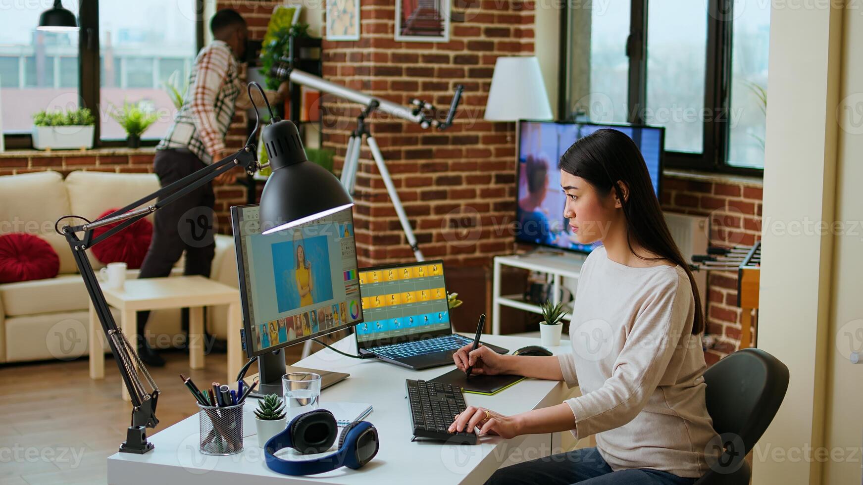 Creative woman manages photo editing and design projects on her computer in a tech driven workspace, using digital tools to enhance productivity in the graphic design industry. Camera A.