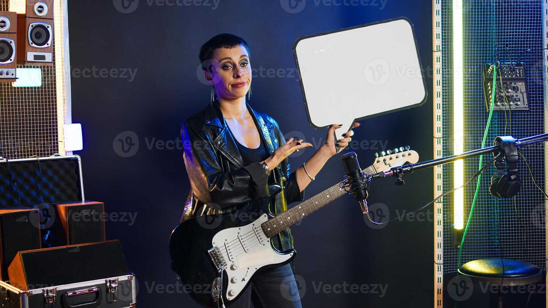 Female rock star performer showing the empty cardboard speech bubble, presenting her rebellious grunge attitude as an artist. Woman musician does a commercial ad with billboard. Camera A. photo