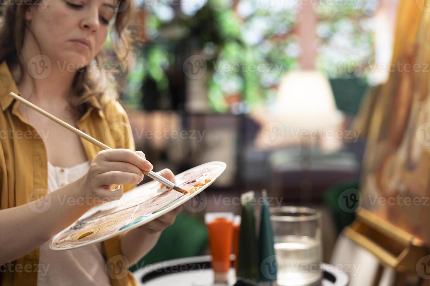 Artist uses her talent and tie dye to create a masterpiece on a canvas in creative workshop, blending colors with a paintbrush. Bringing a rustic artwork to life with a special painting technique. photo