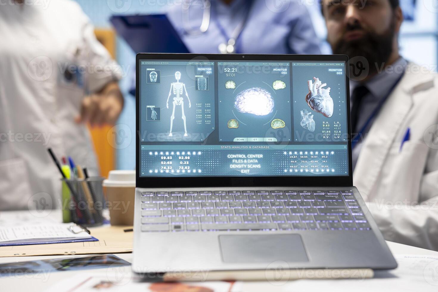 Professional staff reviews test results for potential heart condition diagnosis, looking at anatomy scan on laptop. Specialists with expertise in radiology and cardiology work on disease prevention. photo
