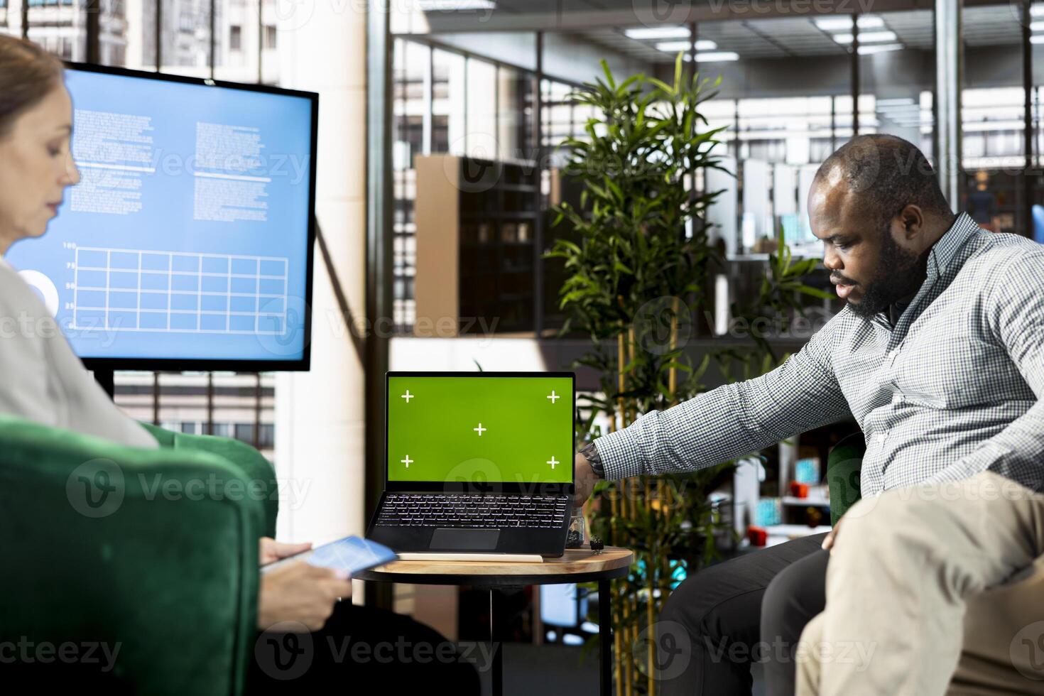 Isolated screen laptop used by businessman looking at financial charts during business meeting with stakeholder. Mockup notebook next to businesspeople doing research, looking over revenue graphs photo