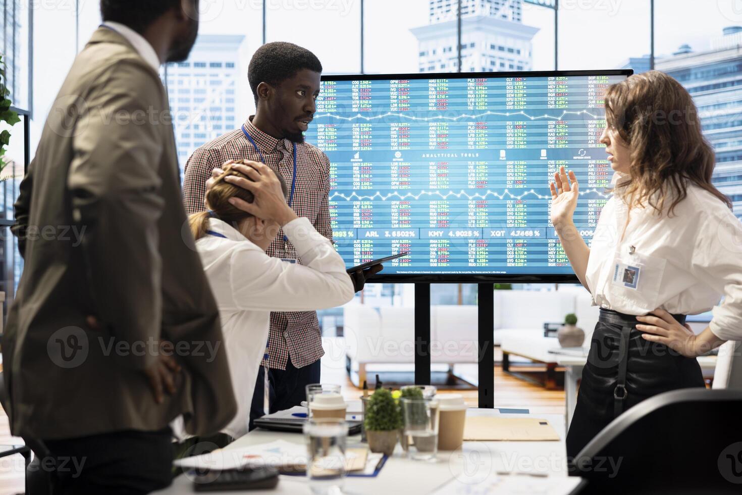 Diverse coworkers gather in a boardroom to brainstorm innovative ideas, analyze market data and develop strategic plans to improve business performance. Enterprise briefing meeting. photo
