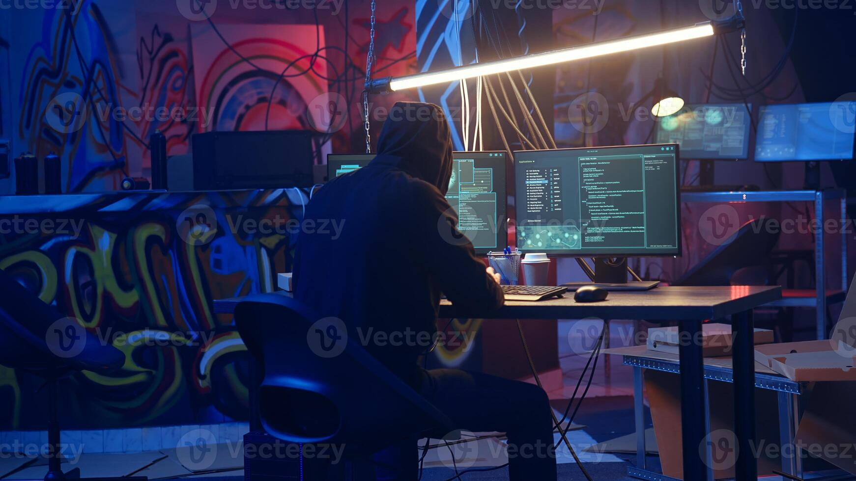 Hooded hacker arriving in hidden underground shelter, prepared to launch DDoS attack on websites. Cybercriminal starting work on script that can crash businesses servers, camera A photo