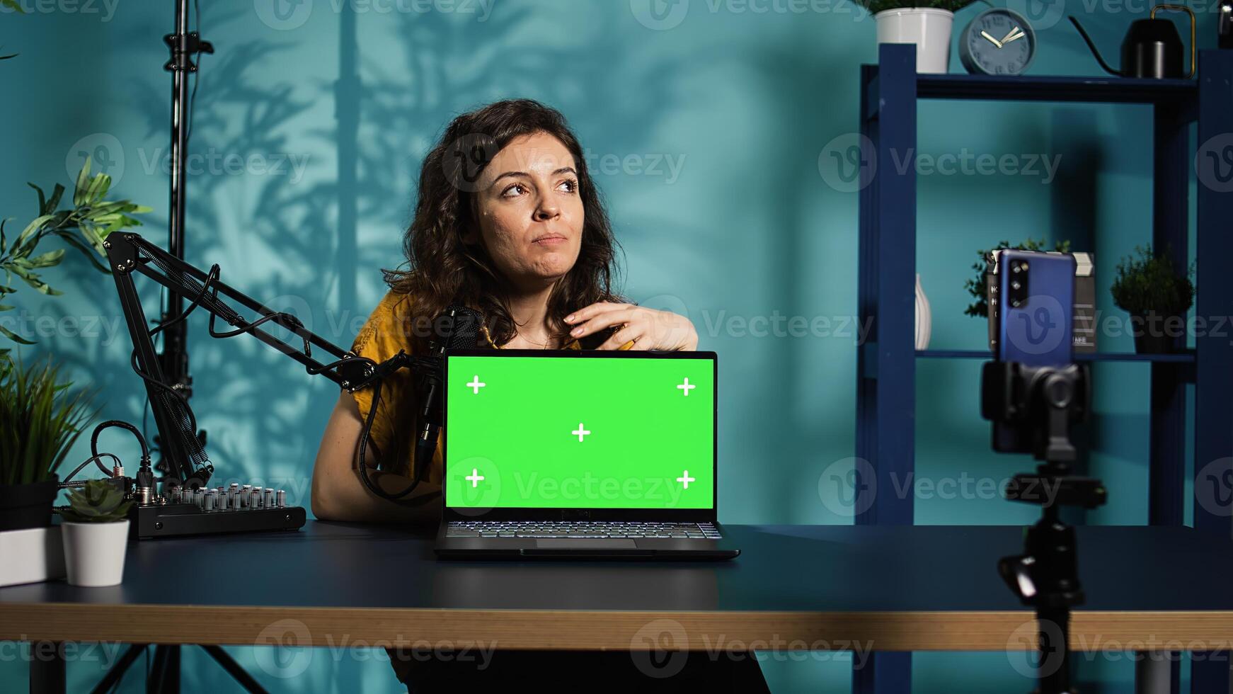 Influencer in home studio using recording tech to capture live broadcast, reviewing chroma key laptop. Online show host filming electronics haul, presenting green screen notebook for viewers, camera B photo