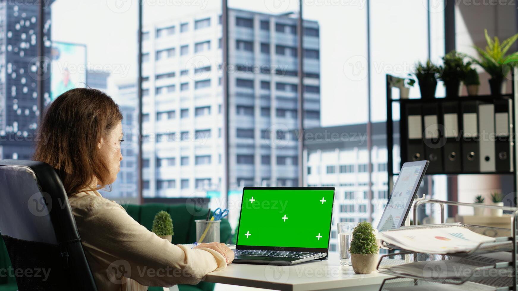 Woman chief executive officer working with mockup copy space screen on device, developing a project for enterprise growth and objectives achievement. Female director with determination. Camera B. photo