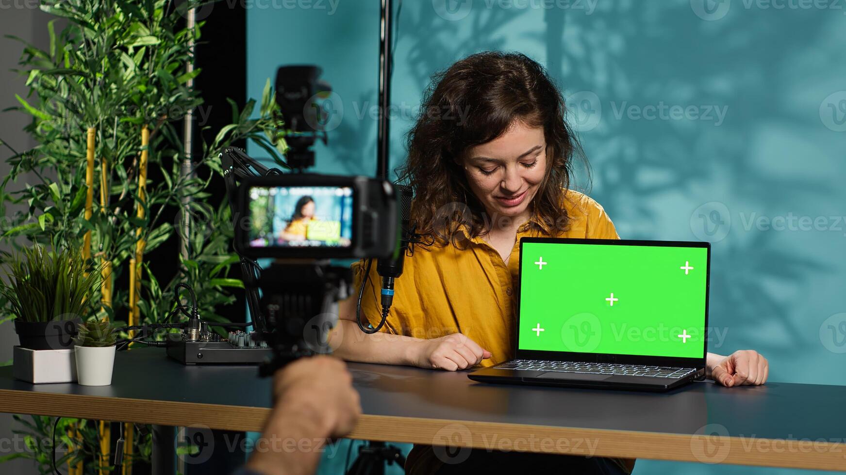 Woman filming herself watching internet videos on mockup laptop requested by viewers. Online influencer reacting to online clips sent by subscribers using green screen notebook, camera A photo