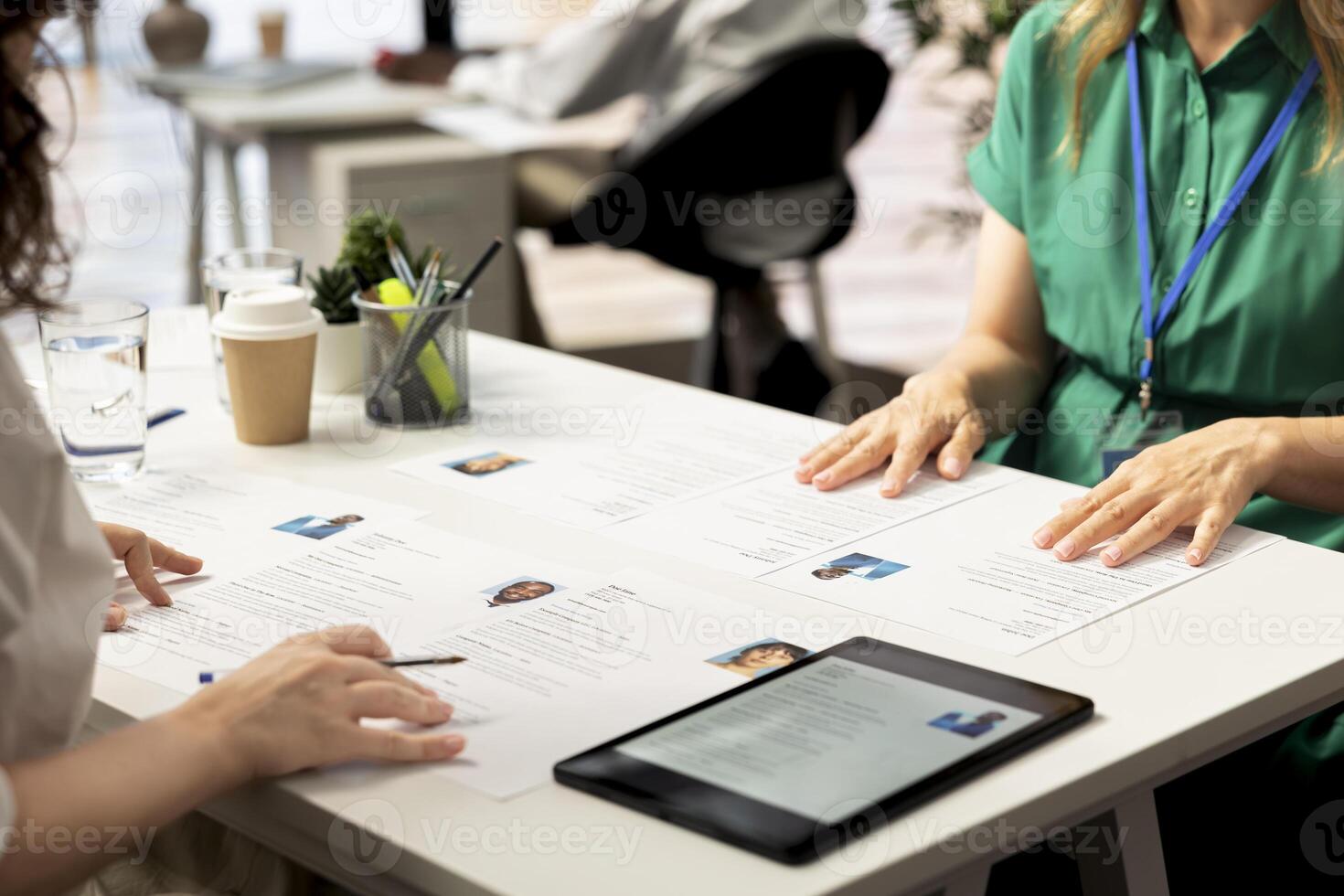 HR staff members using tablet to look at CVs and do background checks to potential job applicants. Headhunters use device to read resumes, attracting qualified candidates for vacant startup position photo