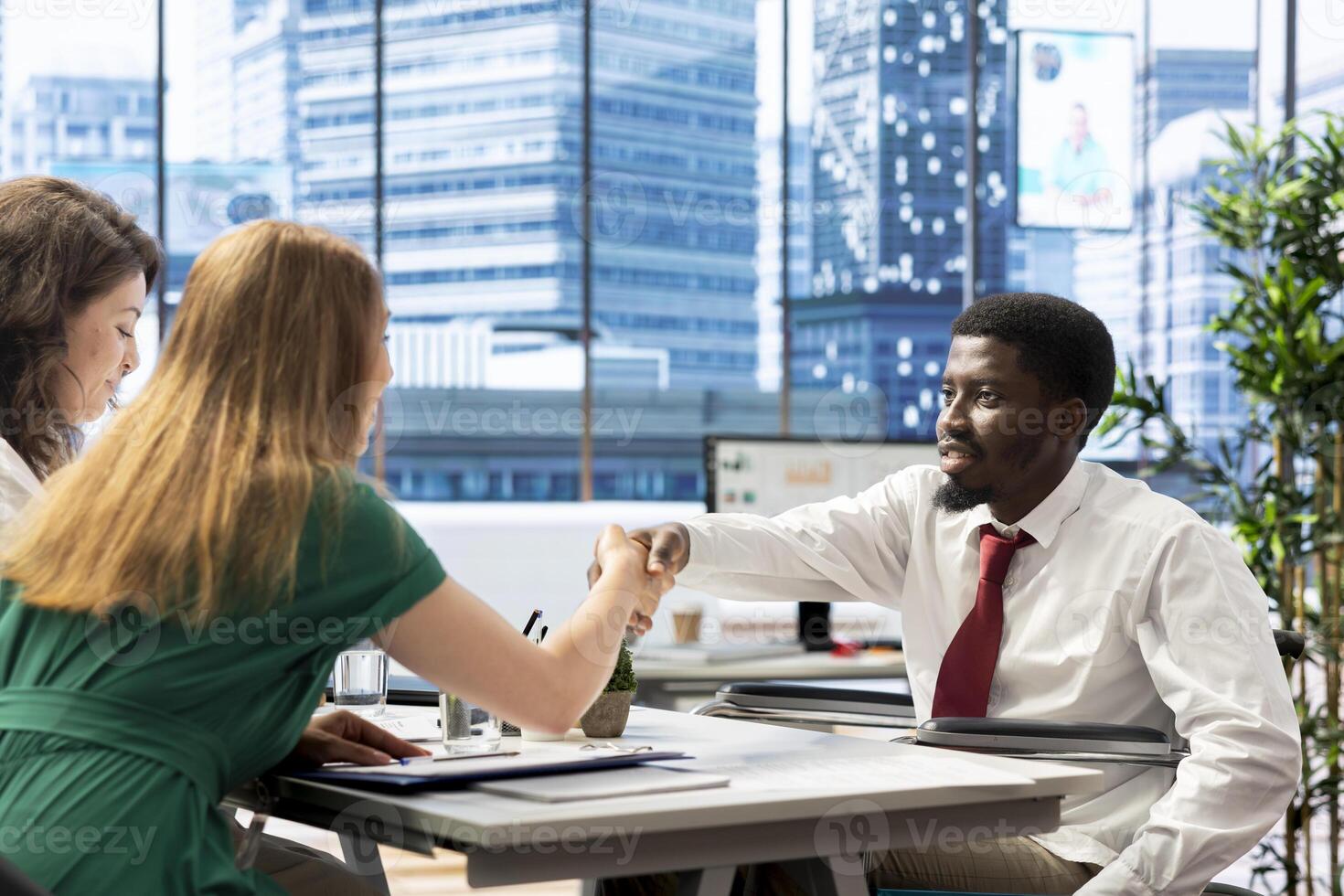 HR expert reviewing candidate with impairment, asking questions about qualifications. Person with disability getting hired for inclusive company after proving enthusiasm for job opportunity photo