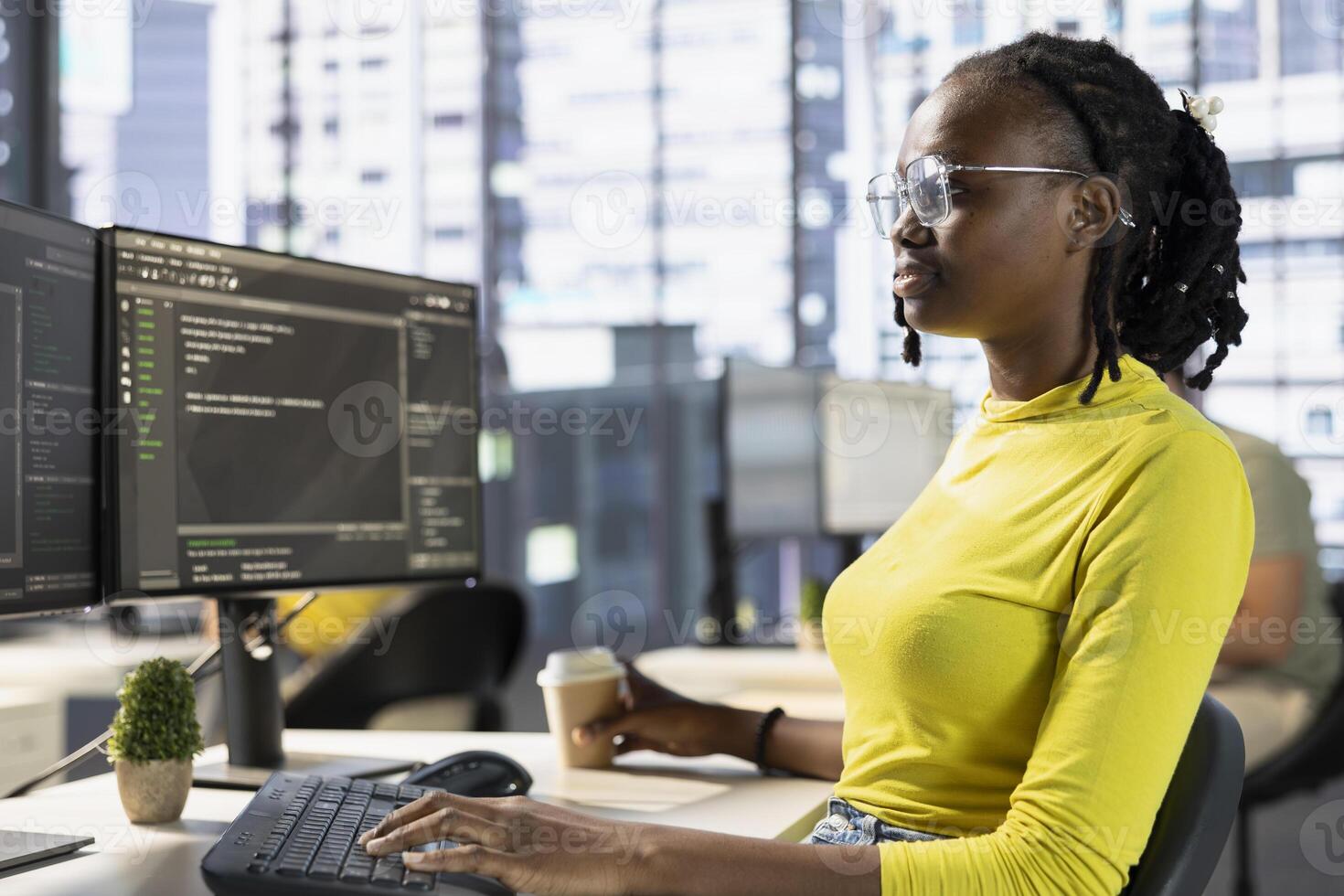 Back end developer managing cloud computing resources and platforms to train machine learning models. IT specialist monitoring and maintaining company systems, checking code on PC monitor photo
