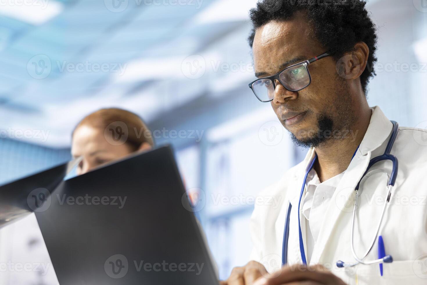 Diverse team of medics examining x ray results and healthcare data in a cabinet meeting, consulting the colleagues before putting a diagnostic. Physicians working together for healthcare recovery. photo