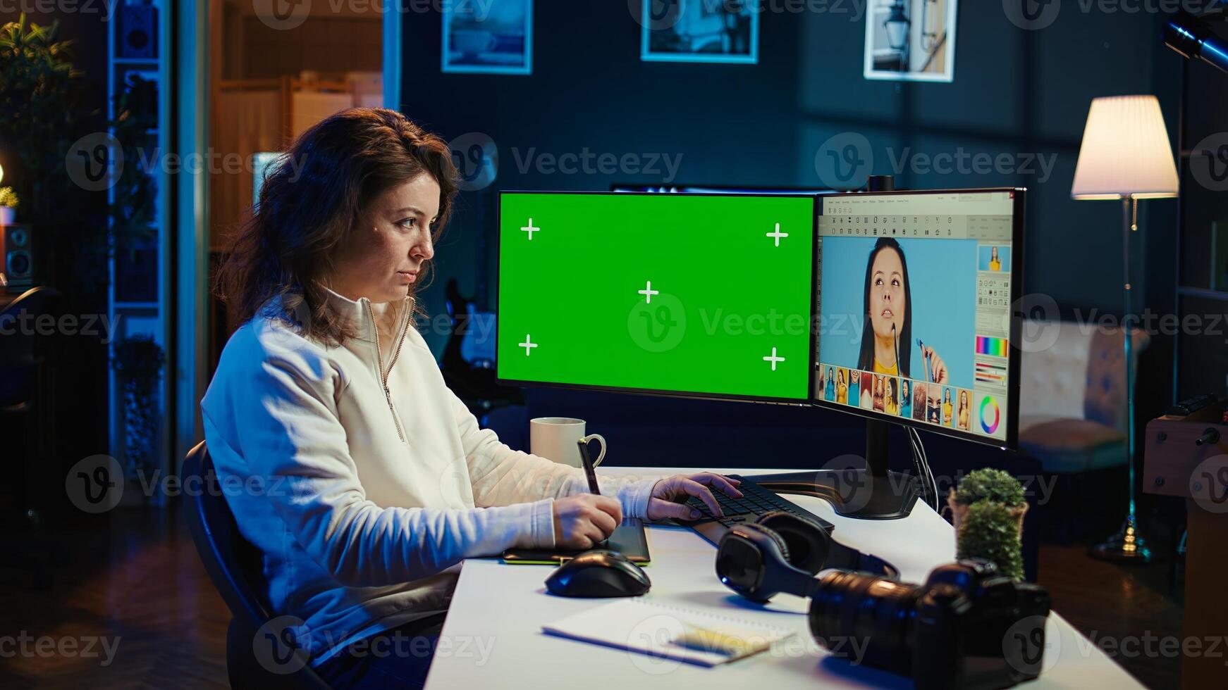 Photo editor using green screen monitor to look at editorial pictures taken with professional camera for fashion magazine. Freelancer browsing images on mockup PC, using graphic tablet, camera B