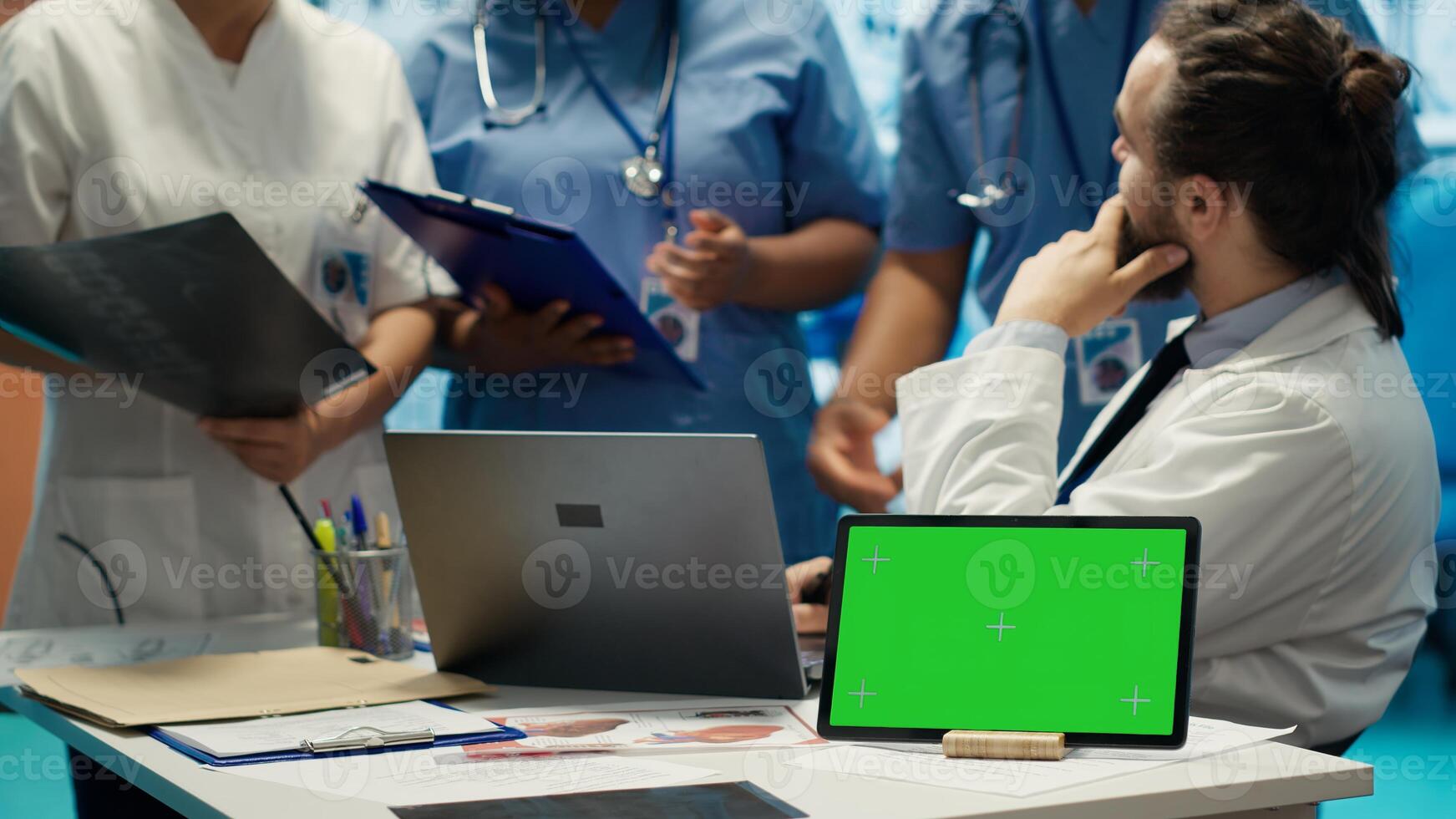 Diverse team of medics analyze x rays next to mockup copy space and discuss treatment plans in a medical office. Healthcare specialists working to provide diagnosis on insurance. Camera A. photo