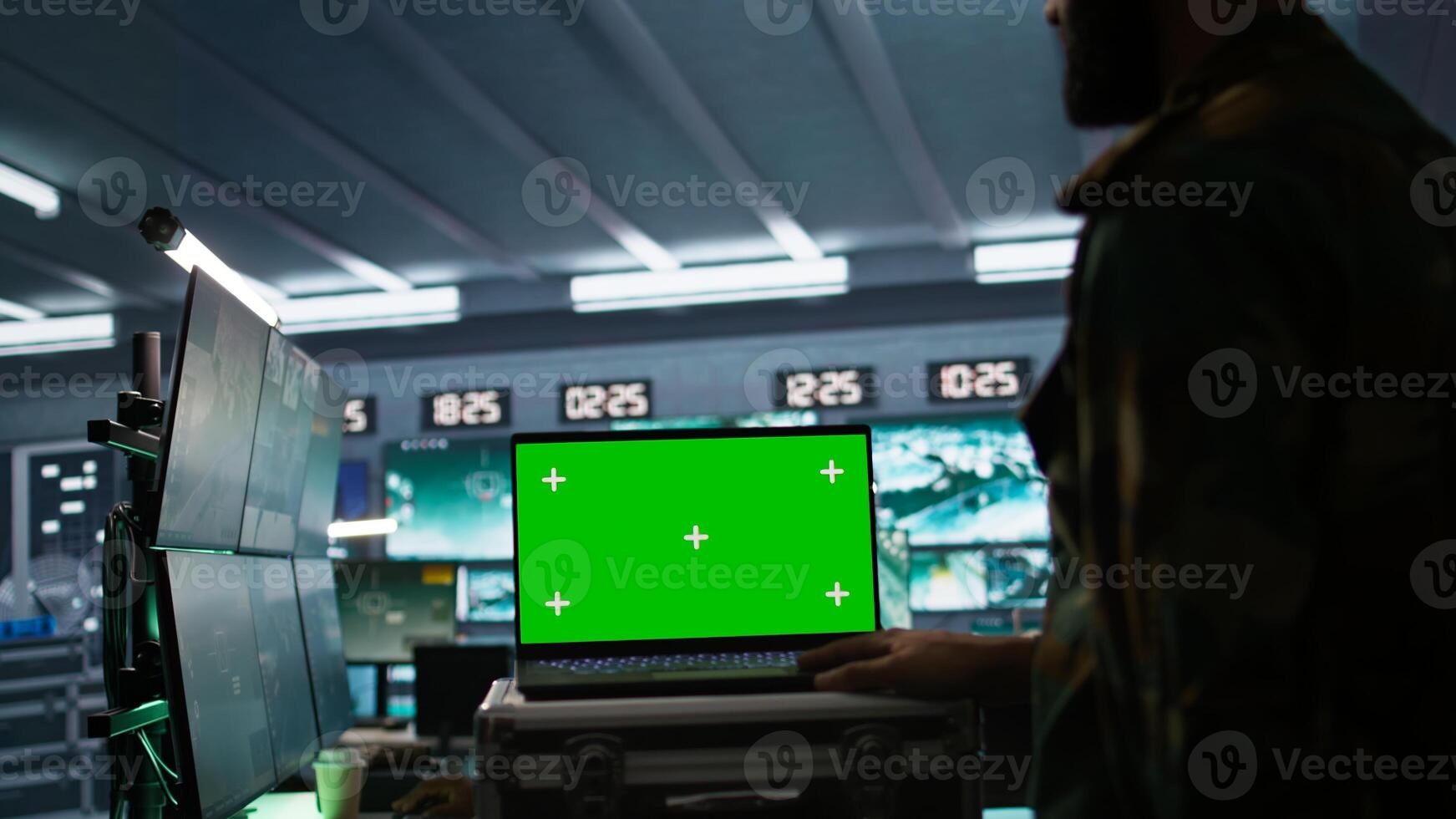 Army specialist working in war room operating surveillance tech, evaluating target data on isolated screen laptop. Soldier engaging enemy forces using chroma key notebook, camera B photo