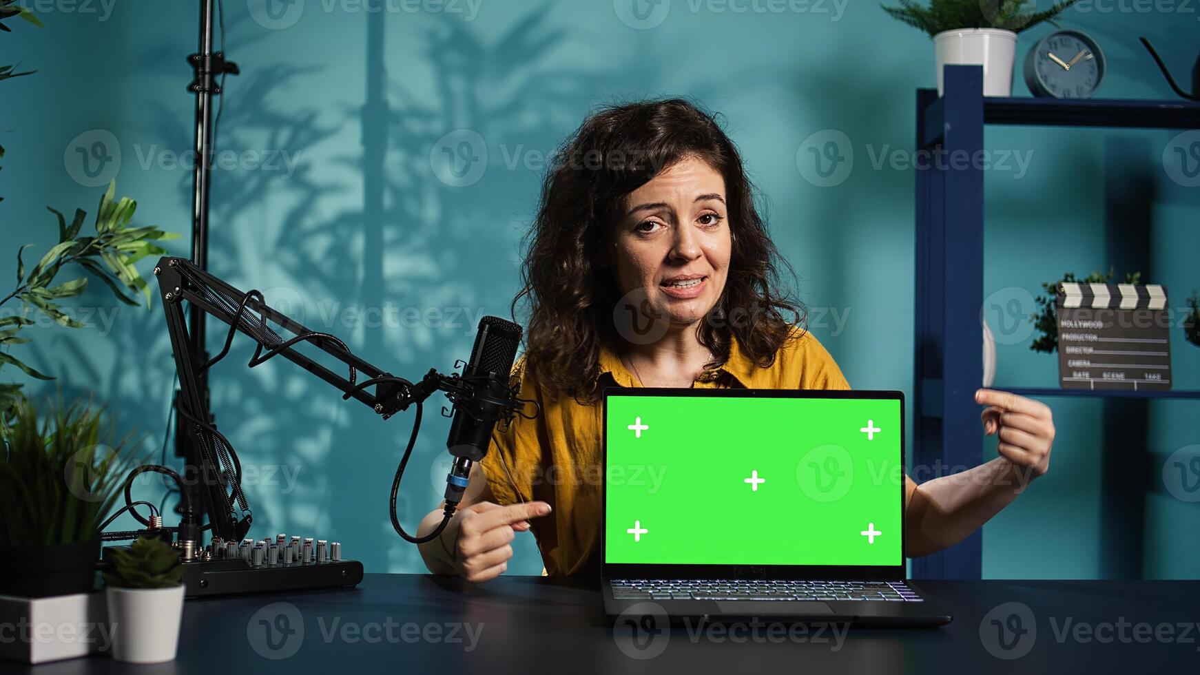 Woman in home studio using recording tech to capture live broadcast, reviewing mockup laptop. Internet show host filming electronics haul, presenting isolated screen notebook for viewers, camera B photo