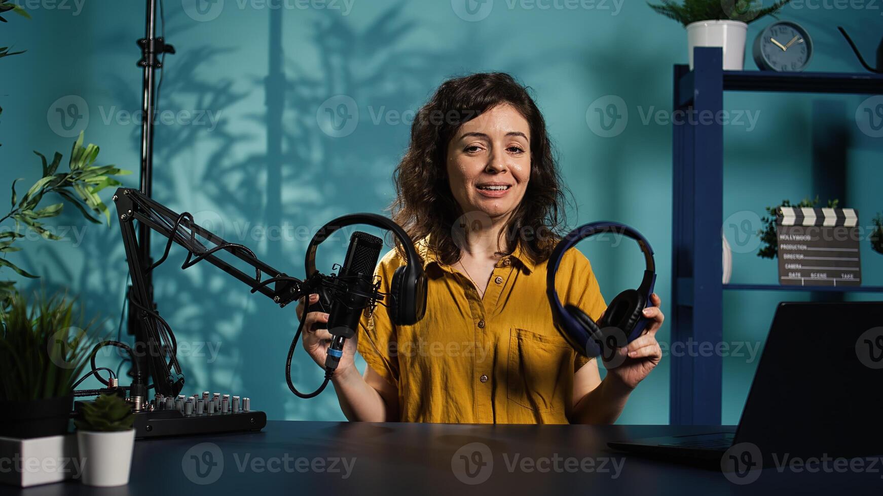 Audio technician presenting professional headphones in different price ranges to audience, comparing them to find winner. Expert recommending listening devices to fans, doing review, camera B photo
