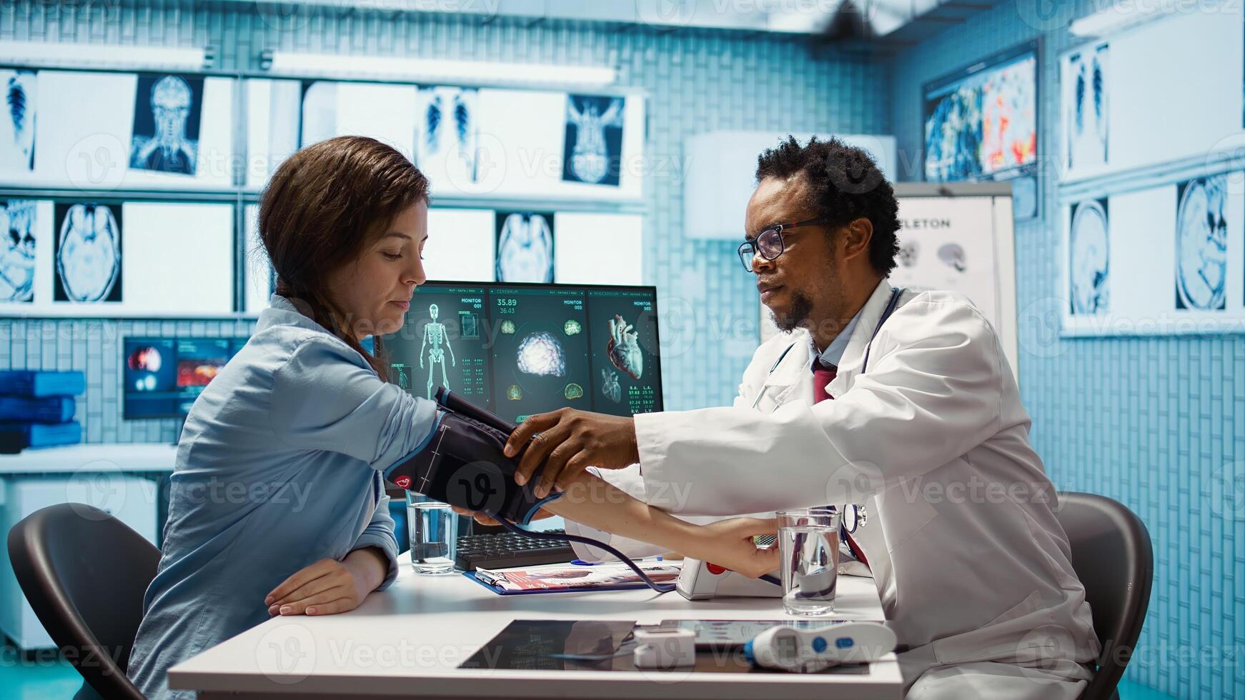 Medical expert taking the pulse and blood pressure with a blood pressure monitor during check up visit, healthcare industry. Physician using modern diagnostic tools for cardiology. Camera B. photo