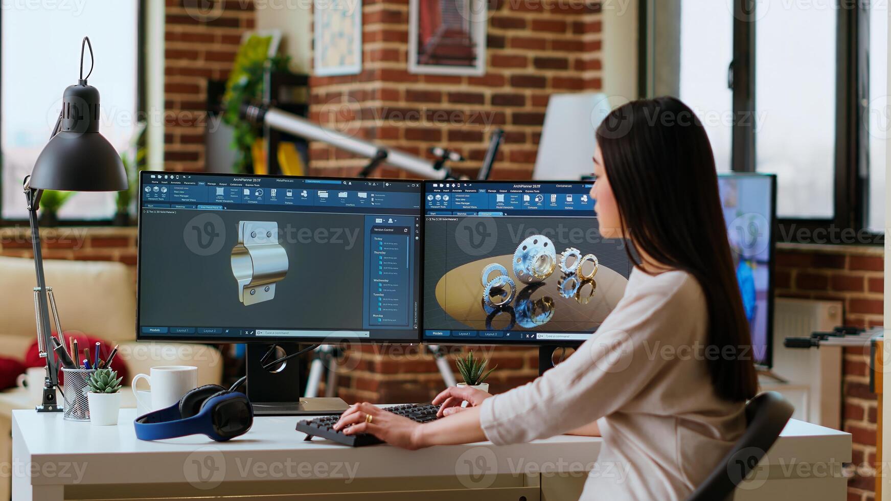 Professional industrial designer working with CAD software on dual monitors, creating 3D prototypes for a tech driven environment. 3D modeling software for innovative design. Camera B. photo