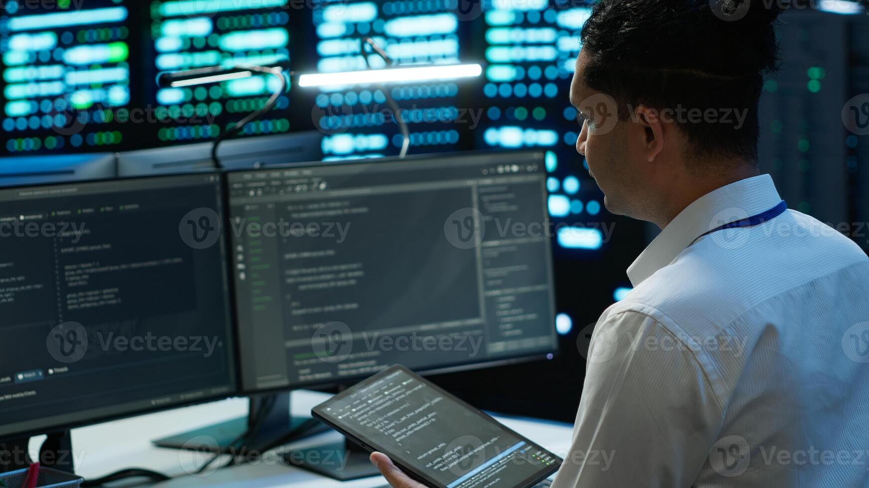 System administrator in data center installing software on computer, troubleshooting issues using tablet. IT staff member in server hub establishing performance benchmarks, camera A photo