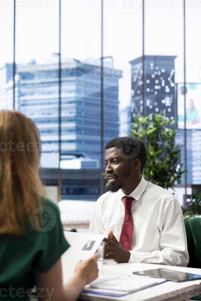 HR employee focusing on ensuring cheerful job candidate possesses necessary qualifications fitting for company culture. Headhunter negotiating salary package and other benefits with smiling applicant photo