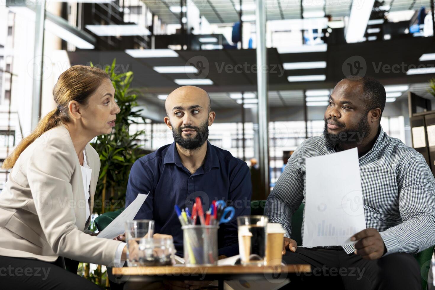 Businesspeople in office looking through financial business documents. Employees in workspace checking accounting figures, finishing tedious paperwork, debating about data photo