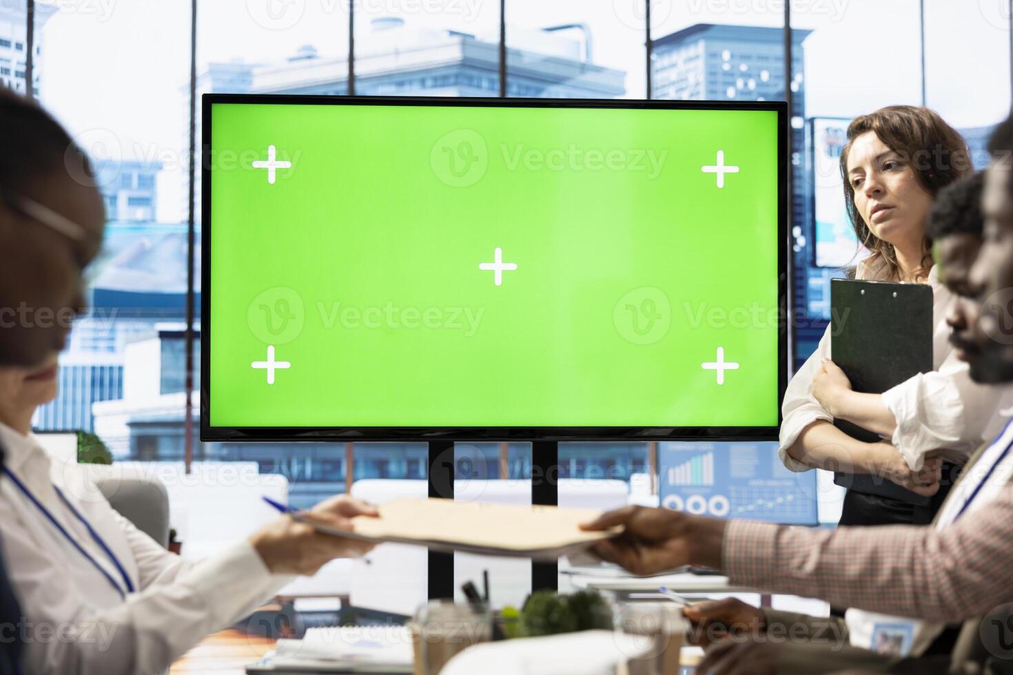 Employees and investors participating in a briefing next to isolated copy space display, reviewing economic indicators and performance metrics. Work team discussing finance planning. photo