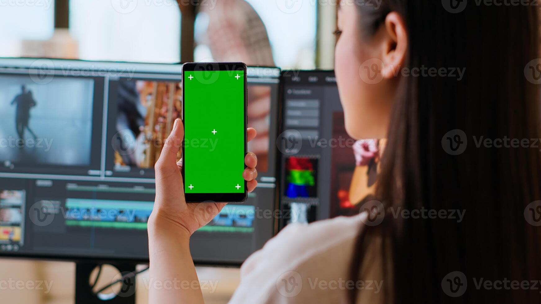 Asian woman working from home as a freelance editor, using isolated mockup display and mixing software. Creative workspace equipped with dual monitors and tech tools. Camera B. photo