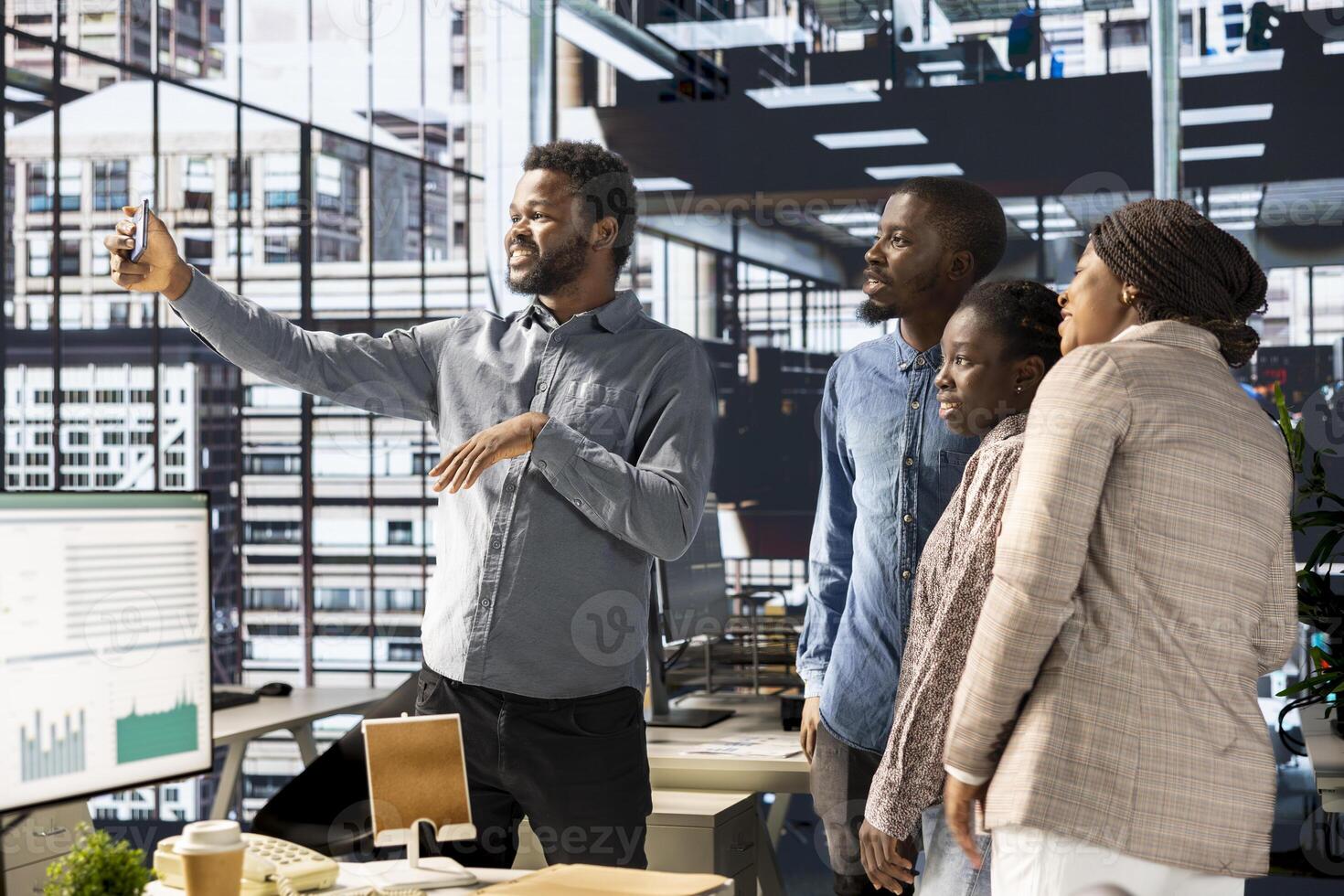 African american business workers smiling at pictures in the office, taking a break from administrative tasks and enjoying photos. Black employees friendly staff work in an enterprise. photo