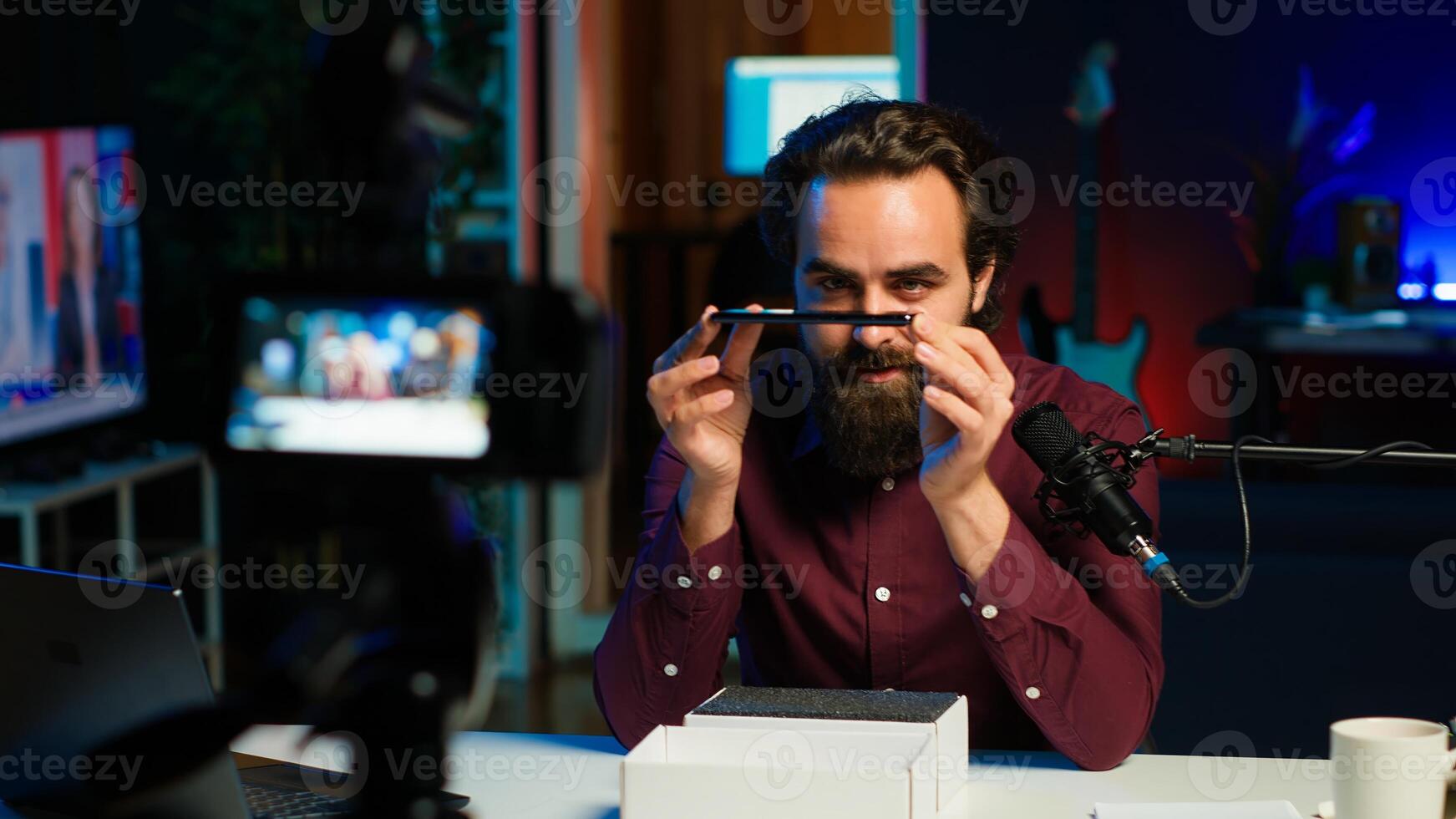 Tech guru assessing smartphone performance, feeling happy with high quality components used. Content creator shoots mobile phone review for online channel, recommending it, camera A photo